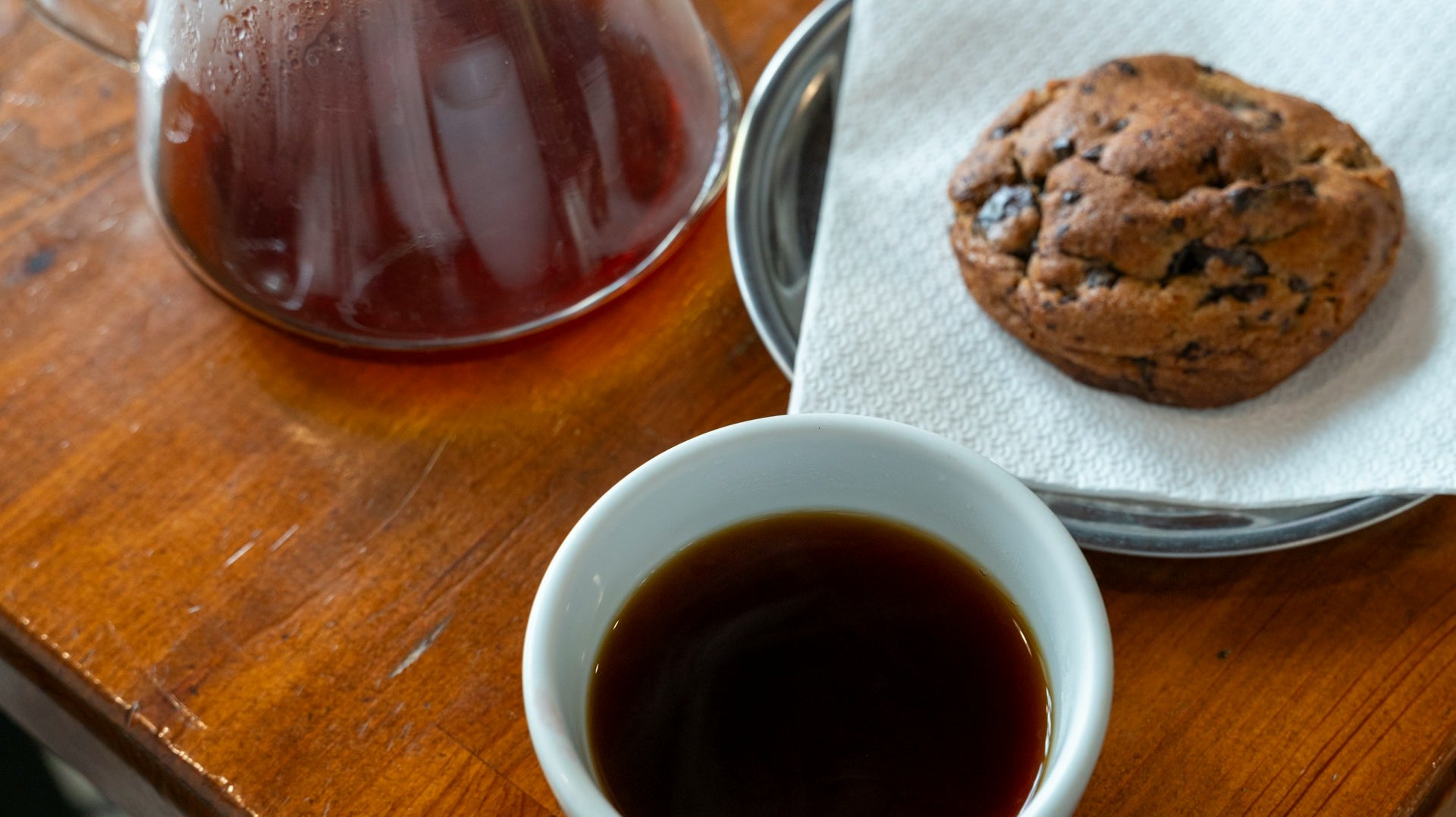 Dégustation d'un bon café avec une tasse blanche sur table en bois et avec un biscuit