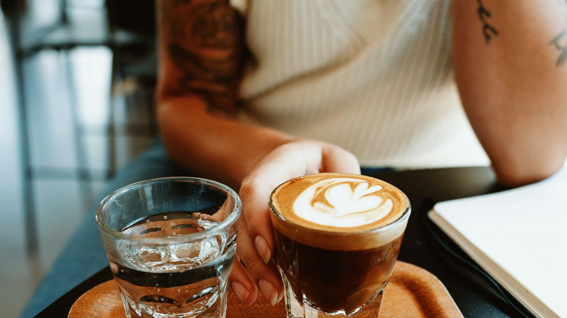 Préparation d'un cortado dans un café de spécialité avec verre d'eau