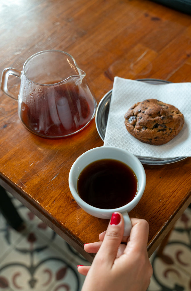 Dégustation d'un bon café avec une tasse blanche sur table en bois et avec un biscuit