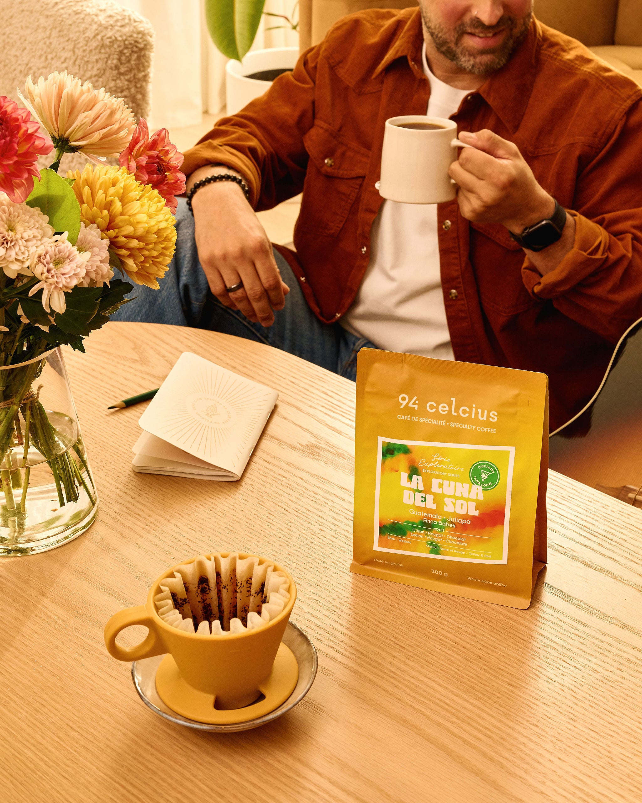 94 celcius sac jaune sur table avec homme fin trentaine buvant un excellent café filtre