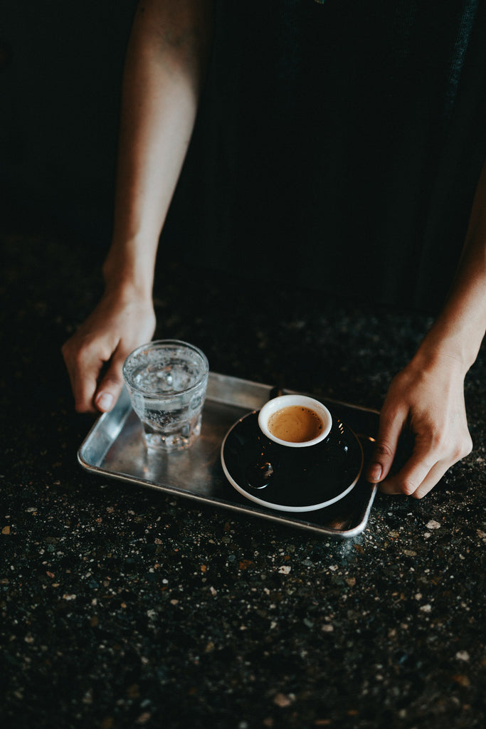 Café Espresso servi avec une eau pétillante par un Barista Montréal